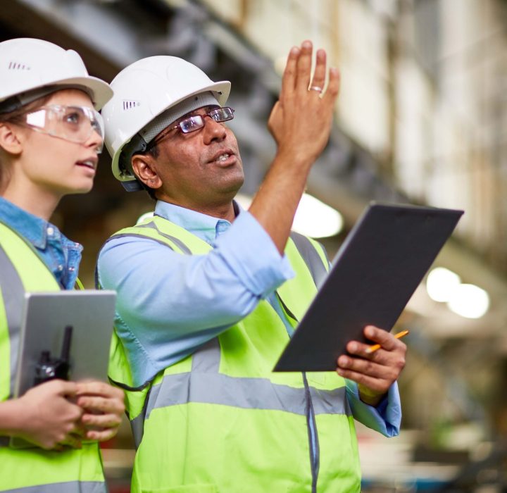 a man and woman wearing safety vests and helmets